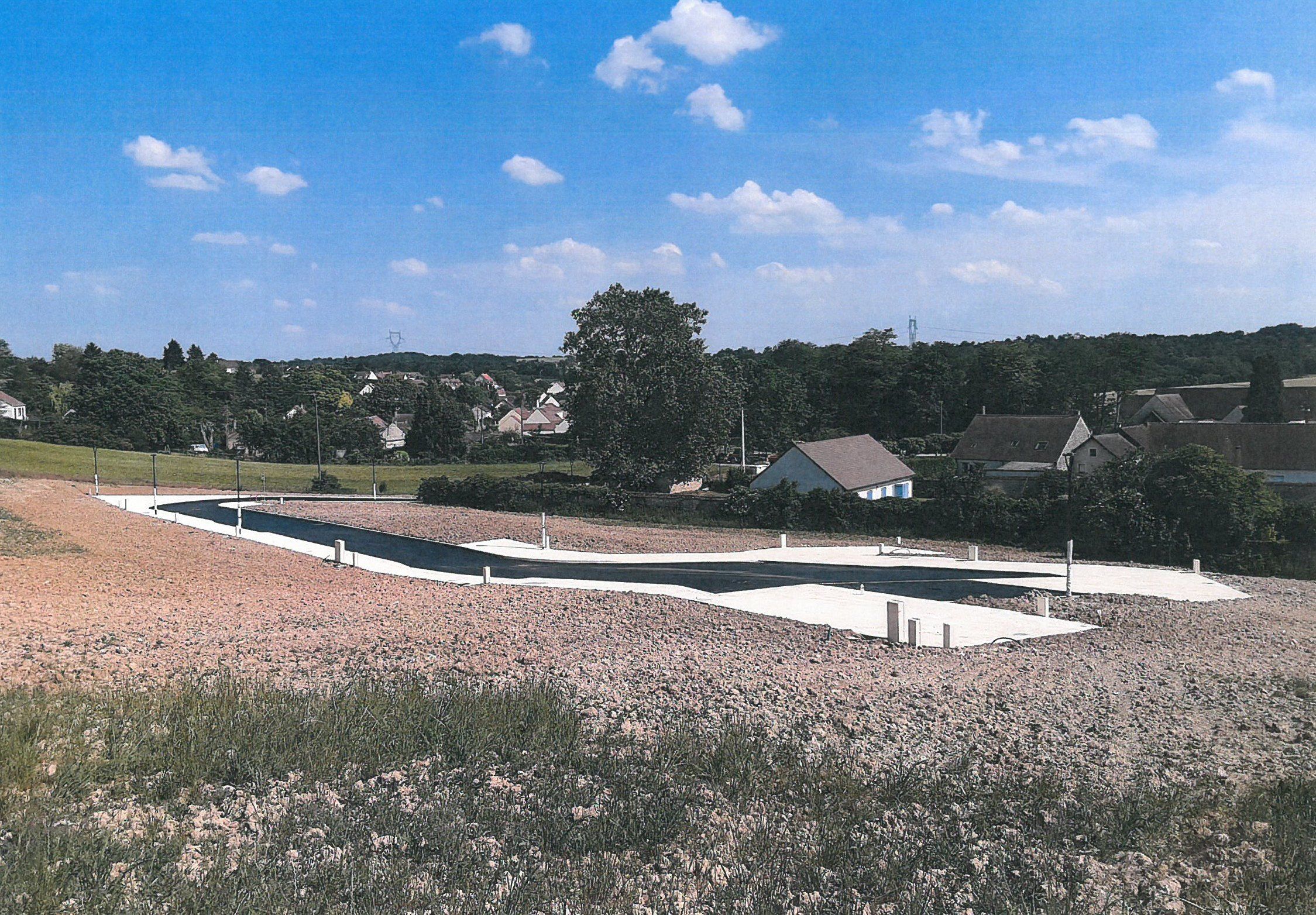 Lotissement de Salins : la voirie neuve et les lots, avec le village en fond