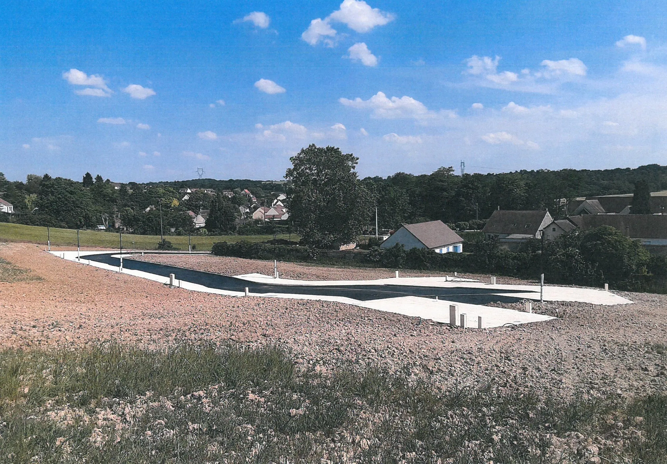 Lotissement de Salins : la voirie neuve et les lots, avec le village en fond